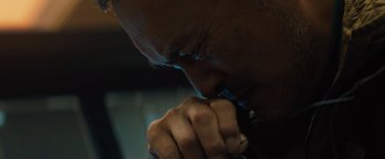 Movie still from “Godzilla: King of the Monsters” (2019), directed by Michael Dougherty – A man's face while holding a pen; Extreme Close Up shot, Low angle