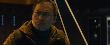Movie still from “Godzilla: King of the Monsters” (2019), directed by Michael Dougherty – A person wearing glasses and a jacket; Close Up shot, Low angle