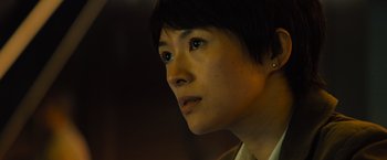 Movie still from “Godzilla: King of the Monsters” (2019), directed by Michael Dougherty – A person with short black hair; Close Up shot, Low angle
