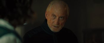 Movie still from “Godzilla: King of the Monsters” (2019), directed by Michael Dougherty – An older man with a beard and a black jacket; Close Up shot, Low angle