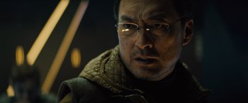 Movie still from “Godzilla: King of the Monsters” (2019), directed by Michael Dougherty – A person wearing glasses and a jacket; Close Up shot, Low angle