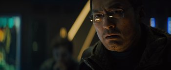 Movie still from “Godzilla: King of the Monsters” (2019), directed by Michael Dougherty – A person wearing glasses and a jacket; Close Up shot, Over the shoulder angle