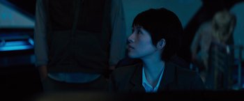 Movie still from “Godzilla: King of the Monsters” (2019), directed by Michael Dougherty – A person sitting in a dark room looking up; Close Up shot, Low angle