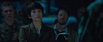 Movie still from “Godzilla: King of the Monsters” (2019), directed by Michael Dougherty – A man and a woman looking at a cell phone in the dark; Close Up shot, Over the shoulder angle