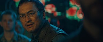 Movie still from “Godzilla: King of the Monsters” (2019), directed by Michael Dougherty – A person wearing glasses; Close Up shot, Over the shoulder angle
