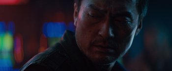 Movie still from “Godzilla: King of the Monsters” (2019), directed by Michael Dougherty – A person with his eyes closed; Close Up shot, Over the shoulder angle