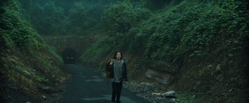 Movie still from “Godzilla: King of the Monsters” (2019), directed by Michael Dougherty – A person walking down a street with a backpack; Wide shot, Low angle