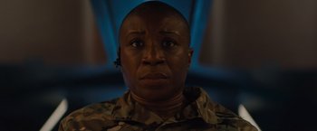 Movie still from “Godzilla: King of the Monsters” (2019), directed by Michael Dougherty – A woman in a military uniform stares into the camera; Close Up shot, Low angle