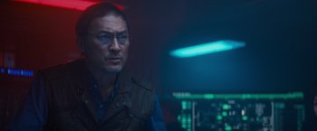 Movie still from “Godzilla: King of the Monsters” (2019), directed by Michael Dougherty – A man with glasses is looking into the distance; Close Up shot, Over the shoulder angle