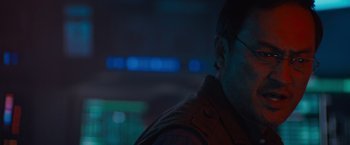 Movie still from “Godzilla: King of the Monsters” (2019), directed by Michael Dougherty – A person wearing a red vest; Close Up shot, Over the shoulder angle