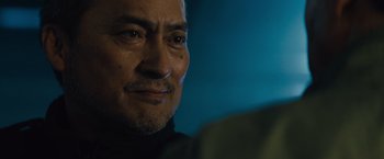 Movie still from “Godzilla: King of the Monsters” (2019), directed by Michael Dougherty – A man's face in a dark room; Close Up shot, Over the shoulder angle