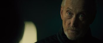 Movie still from “Godzilla: King of the Monsters” (2019), directed by Michael Dougherty – An old man with a beard and a black jacket; Close Up shot, Low angle