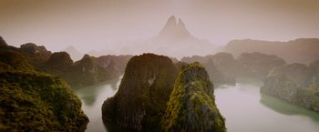 Movie still from “Godzilla: King of the Monsters” (2019), directed by Michael Dougherty – A view of a large body of water with a mountain in the background; Extreme Wide shot, Overhead angle