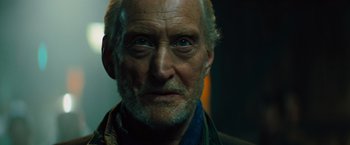 Movie still from “Godzilla: King of the Monsters” (2019), directed by Michael Dougherty – An old man with a beard and a goatee looking at the camera; Close Up shot, Low angle