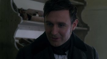 Movie still from “Ammonite” (2020), directed by Francis Lee – A person wearing a suit and tie; Close Up shot, Over the shoulder angle