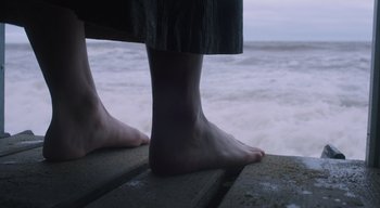 Movie still from “Ammonite” (2020), directed by Francis Lee – A person's bare feet on a pier; Extreme Close Up shot, Low angle