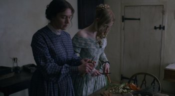 Movie still from “Ammonite” (2020), directed by Francis Lee – Two women standing next to each other cutting vegetables; Medium shot, Over the shoulder angle