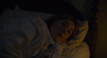 Movie still from “Ammonite” (2020), directed by Francis Lee – A woman sleeping in a bed with a white blanket; Close Up shot, High angle