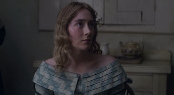 Movie still from “Ammonite” (2020), directed by Francis Lee – A woman with long blonde hair wearing a blue dress; Close Up shot, Over the shoulder angle