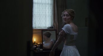 Movie still from “Ammonite” (2020), directed by Francis Lee – A woman in a white dress standing in front of a mirror; Medium shot, Over the shoulder angle