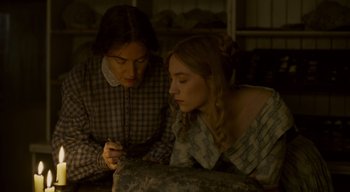 Movie still from “Ammonite” (2020), directed by Francis Lee – Two women are looking at something on a table; Close Up shot, High angle