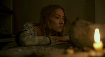 Movie still from “Ammonite” (2020), directed by Francis Lee – A woman is laying on the ground looking at the camera; Close Up shot, High angle