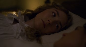 Movie still from “Ammonite” (2020), directed by Francis Lee – A woman laying in a bed with her head on the pillow; Close Up shot, High angle