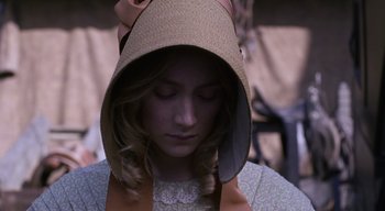 Movie still from “Ammonite” (2020), directed by Francis Lee – A woman wearing a hat with a bow around it's head; Close Up shot, High angle