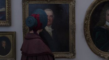 Movie still from “Ammonite” (2020), directed by Francis Lee – A woman wearing a blue hat looking at a painting; Extreme Close Up shot, Over the shoulder angle