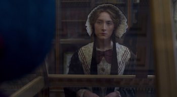 Movie still from “Ammonite” (2020), directed by Francis Lee – A young woman in a victorian dress looking out of a window; Medium shot, Over the shoulder angle