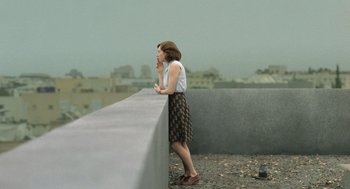 Movie still from “Golda” (2023), directed by Guy Nattiv – A woman leaning on a wall on top of a building; Wide shot, High angle