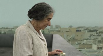 Movie still from “Golda” (2023), directed by Guy Nattiv – An older woman is looking down at a piece of paper; Close Up shot, Over the shoulder angle