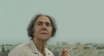Movie still from “Golda” (2023), directed by Guy Nattiv – An older woman holding a cigarette in her hand; Close Up shot, Low angle