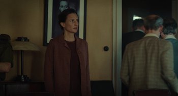 Movie still from “Golda” (2023), directed by Guy Nattiv – A woman standing in front of a mirror in a room; Medium shot, Over the shoulder angle