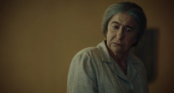 Movie still from “Golda” (2023), directed by Guy Nattiv – An older woman is looking at the camera; Close Up shot, Over the shoulder angle