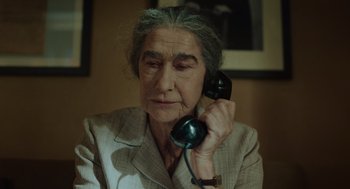 Movie still from “Golda” (2023), directed by Guy Nattiv – An older woman holding a phone to her ear; Close Up shot, High angle