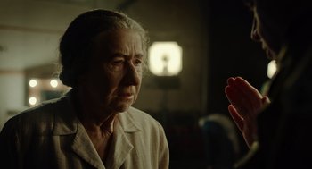 Movie still from “Golda” (2023), directed by Guy Nattiv – An older woman is looking at a person; Close Up shot, Over the shoulder angle