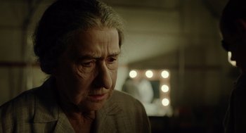 Movie still from “Golda” (2023), directed by Guy Nattiv – An older woman looking down at her face; Close Up shot, Over the shoulder angle