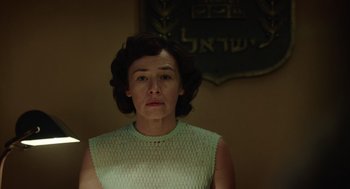 Movie still from “Golda” (2023), directed by Guy Nattiv – A woman in a green dress is looking at the camera; Close Up shot, Low angle