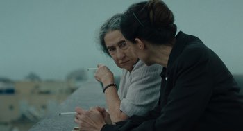 Movie still from “Golda” (2023), directed by Guy Nattiv – Two women sitting next to each other holding cigarettes; Close Up shot, Over the shoulder angle