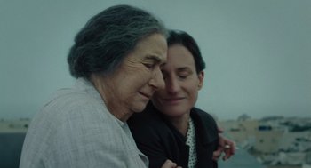 Movie still from “Golda” (2023), directed by Guy Nattiv – Two women are embracing each other outside in the rain; Close Up shot, High angle