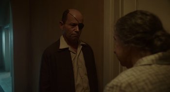 Movie still from “Golda” (2023), directed by Guy Nattiv – A man with a bandage on his eye looking in the mirror; Medium shot, Over the shoulder angle