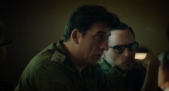 Movie still from “Golda” (2023), directed by Guy Nattiv – Two men in military fatigues sitting next to each other; Close Up shot, Over the shoulder angle