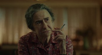 Movie still from “Golda” (2023), directed by Guy Nattiv – An older woman smoking a cigarette while sitting down; Close Up shot, Over the shoulder angle