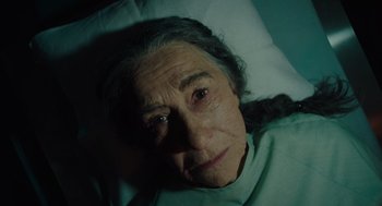 Movie still from “Golda” (2023), directed by Guy Nattiv – An older woman laying in a bed looking at the camera; Close Up shot, High angle