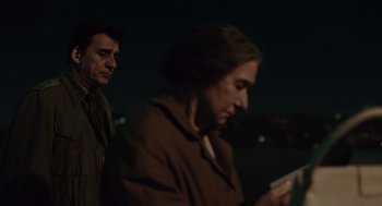 Movie still from “Golda” (2023), directed by Guy Nattiv – A man and a woman standing next to each other in the dark; Medium shot, Over the shoulder angle