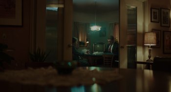 Movie still from “Golda” (2023), directed by Guy Nattiv – Two people sitting at a table in a room; Wide shot, Over the shoulder angle