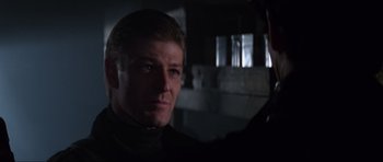 Movie still from “GoldenEye” (1995), directed by Martin Campbell – A person wearing a black shirt; Close Up shot, Over the shoulder angle