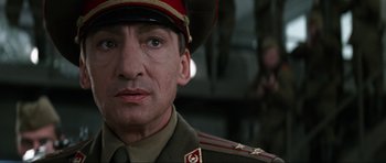 Movie still from “GoldenEye” (1995), directed by Martin Campbell – A person wearing a military uniform; Close Up shot, Low angle