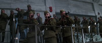 Movie still from “GoldenEye” (1995), directed by Martin Campbell – A group of men dressed in military fatigues holding guns; Wide shot, Low angle